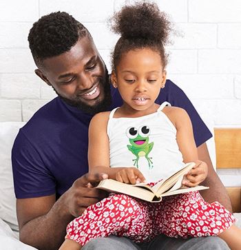 a father and daughter sitting on a bed reading a book